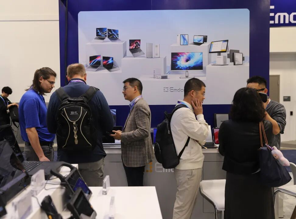 Industry professionals discussing automation solutions around a demonstration unit of Emdoor's Промышленная панель ПК windows 10