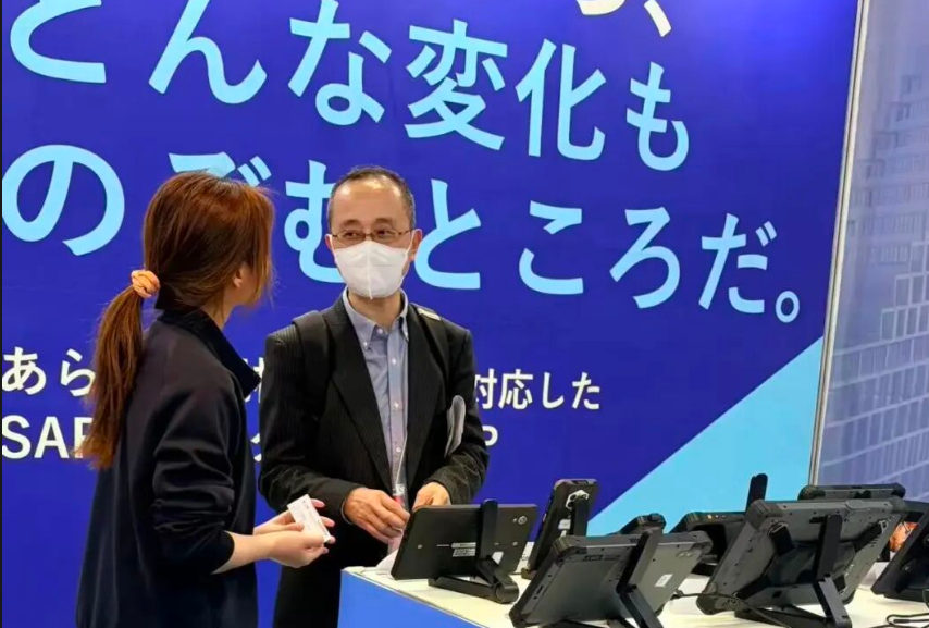  A logistics fleet manager exploring the V82T монтируется на автомобиль terminal at the Emdoor rugged hardware showcase in Tokyo.