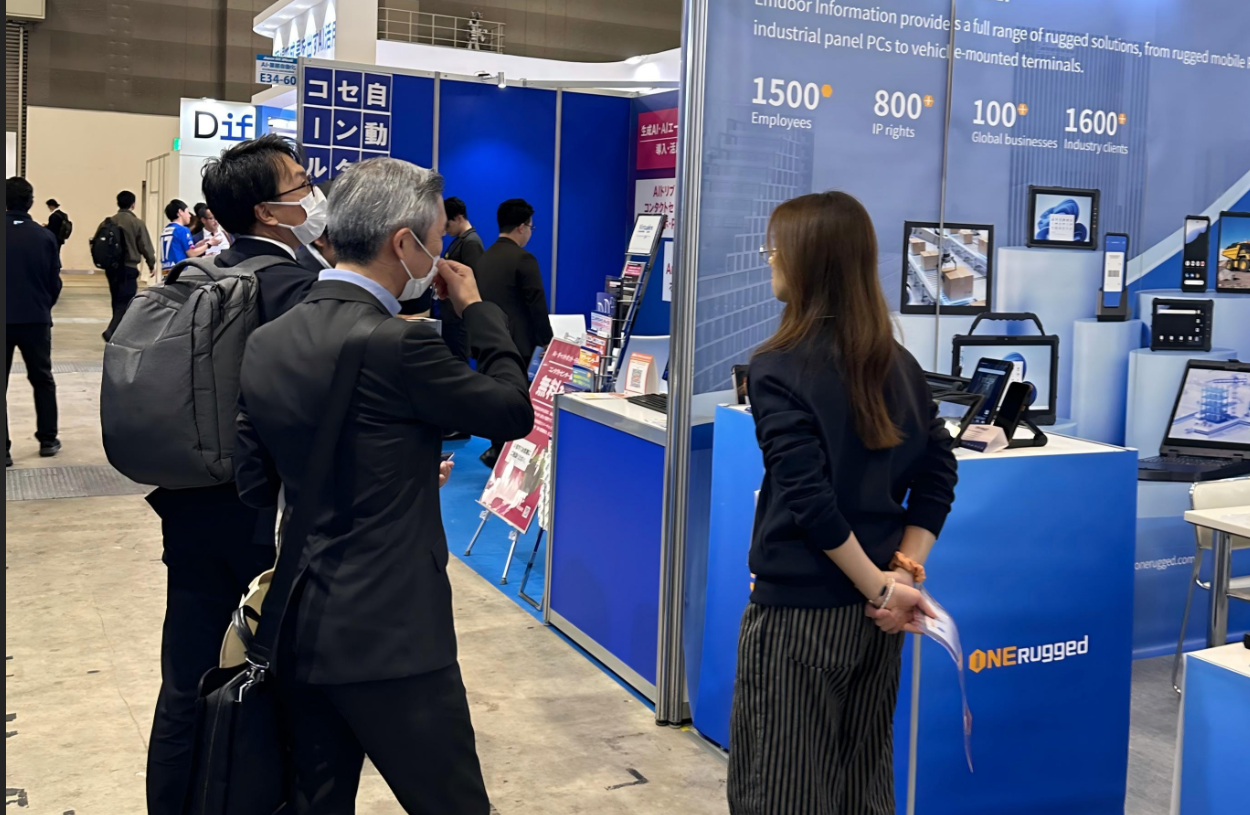 Emdoor hardware engineers demonstrating a tablet with built in barcode scanner for warehouse management to attendees at Japan IT Week.